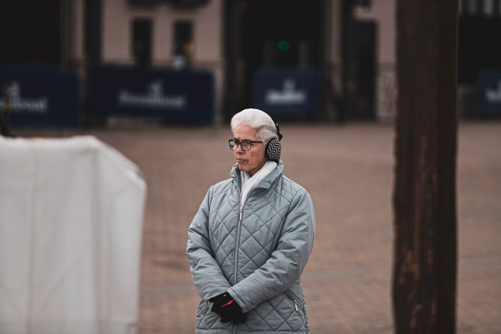 Person in a modern setting holding a smartphone and speaking into it, visually representing a user asking an AI assistant ...