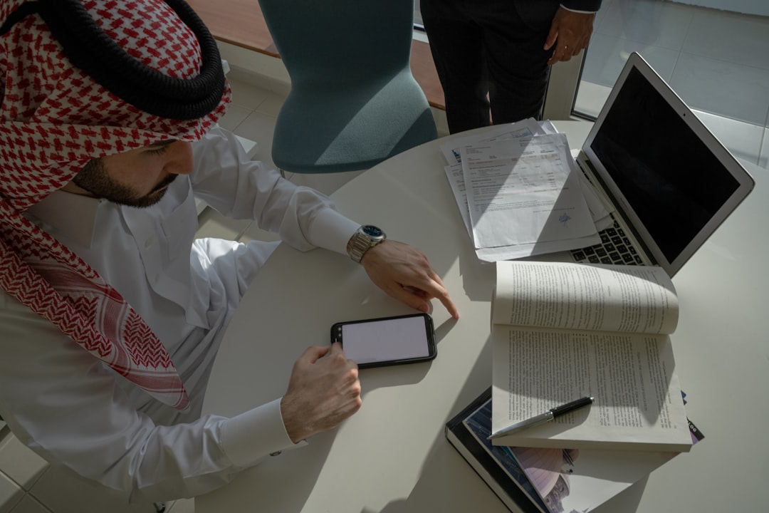 Close-up of a professional handshake taking place through a modern laptop screen, symbolizing the concept of building digi...