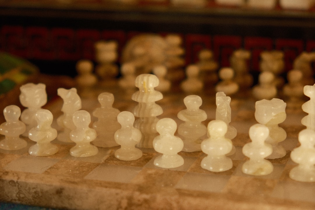 A classic wooden chessboard mid-game, with dramatic lighting highlighting key pieces, representing strategy and foresight in a competitive environment.