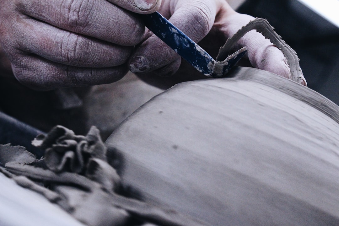 A close-up of an older person's weathered hands using a traditional, well-worn tool, symbolizing wisdom gained from past experience.