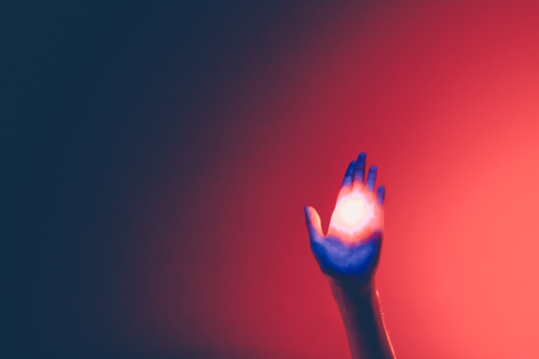 A person's hand calmly touches a glowing, abstract data visualization on a screen, illustrating the human interaction with new AI technology.
