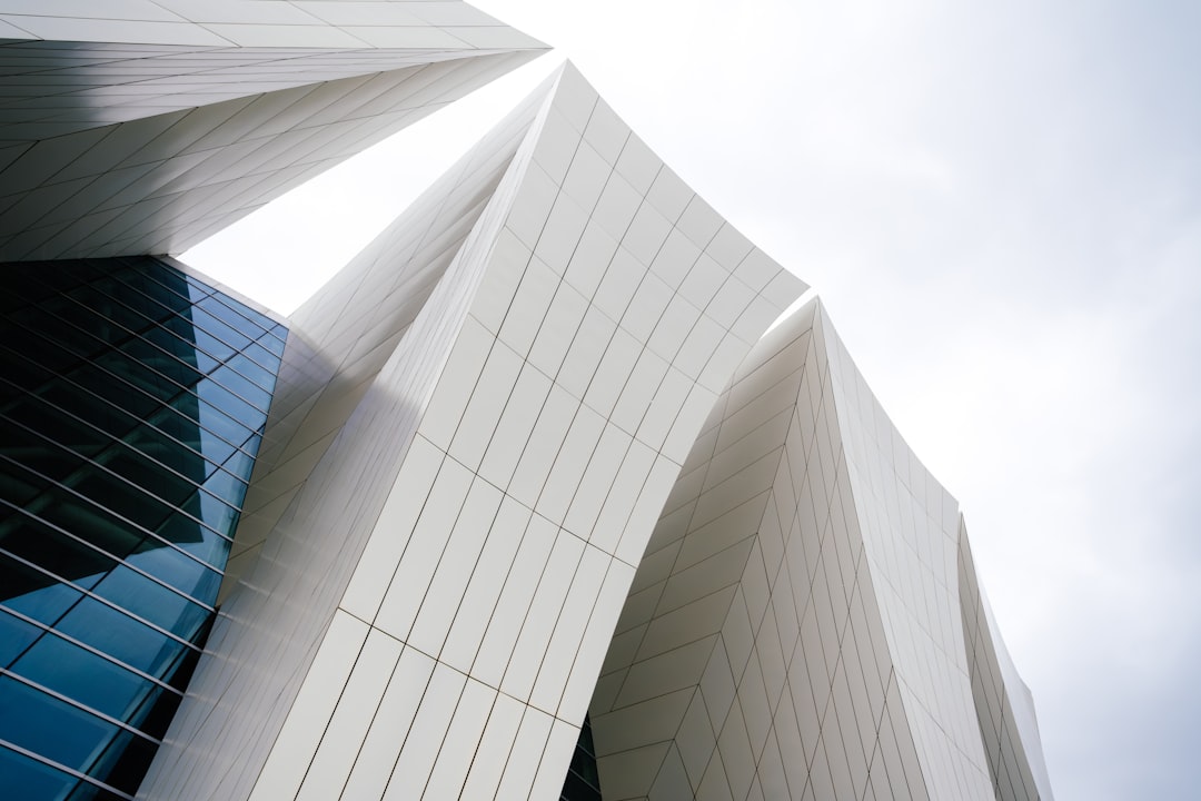 The strong, clean architectural lines at the base of a modern building under a bright sky, illustrating the concept of a solid business foundation that withstands technological shifts.