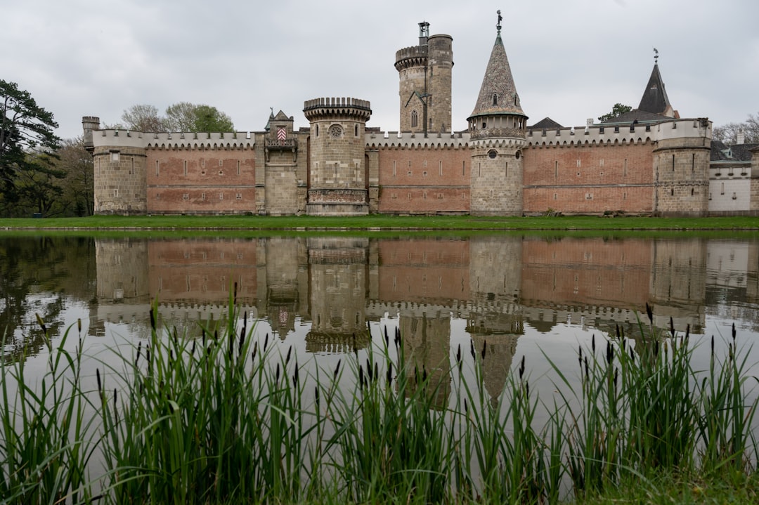 A formidable ancient stone castle surrounded by a wide, protective moat under a clear sky, representing a secure and well-defended digital business presence.