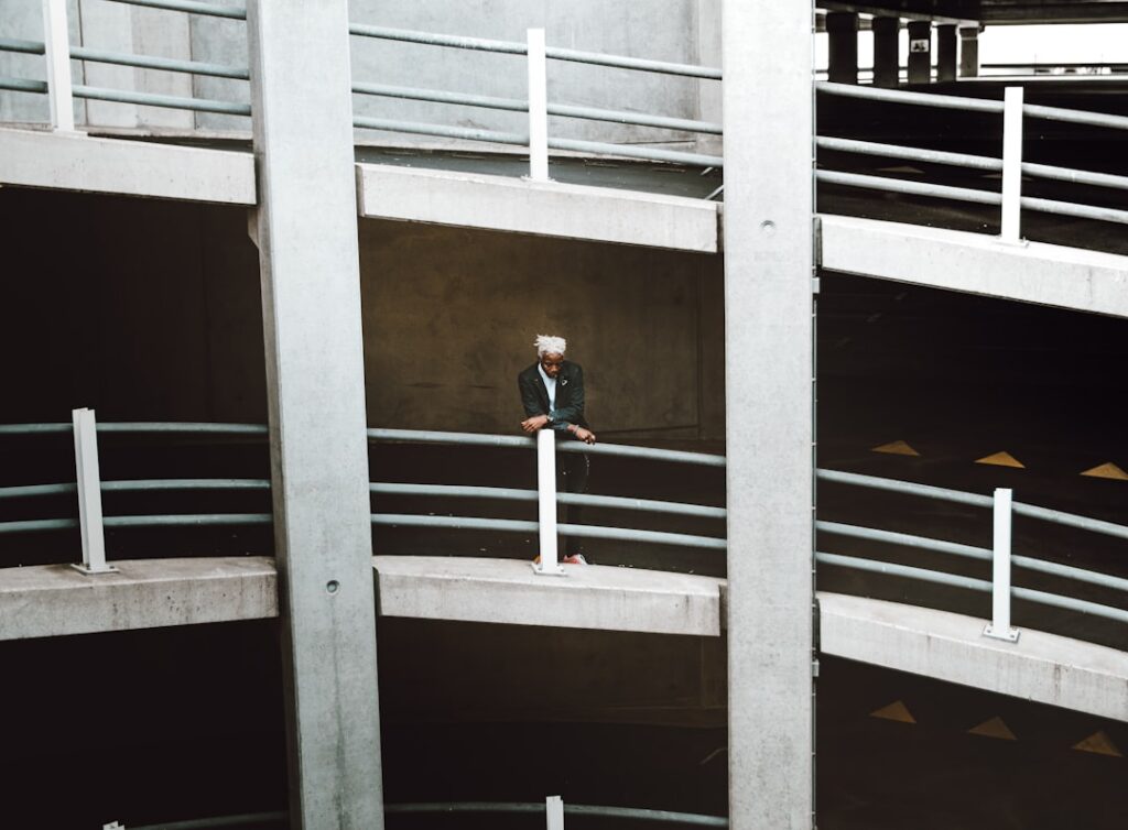 Overhead view of a person in business attire looking lost inside a complex, modern maze, symbolizing the frustration of ch...