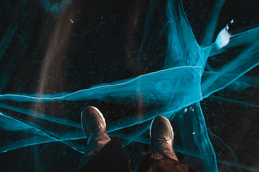 A person's hand reaches out to touch a complex network of glowing blue digital lines, symbolizing the human element connecting with the foundational structure of AI.