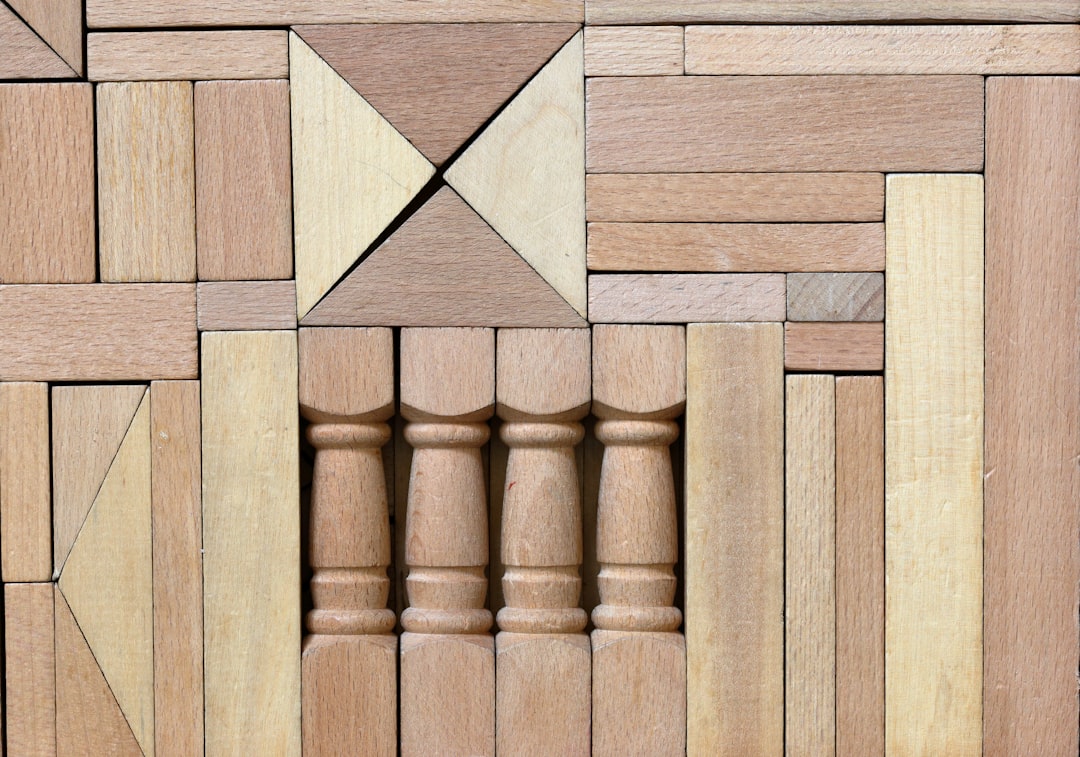A person's hands carefully stacking wooden blocks to build a tall, stable tower on a solid foundation, illustrating the concept of building a strong digital strategy.