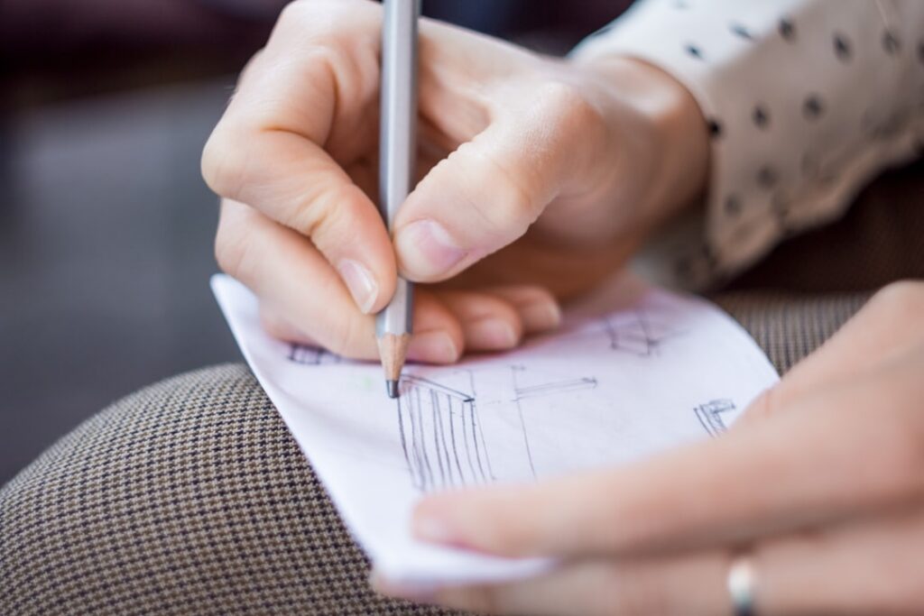 Professional architect meticulously working on detailed blueprints at a modern desk, representing the careful, long-term p...