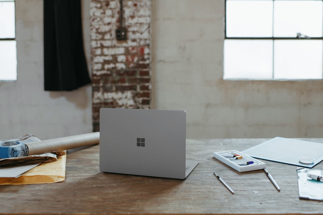 A clean, bright, and modern desk setup featuring architectural blueprints, a sleek laptop, and a cup of coffee, representing the blend of foundational strategy and modern technology in real estate.