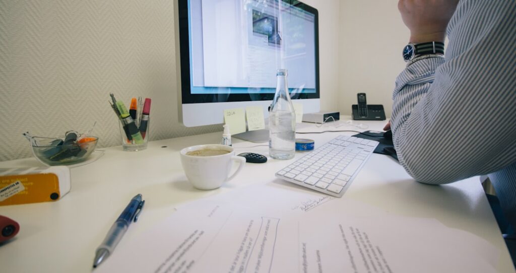 Professional business person sitting at a modern, clean desk and looking intently at a computer screen, symbolizing expert...